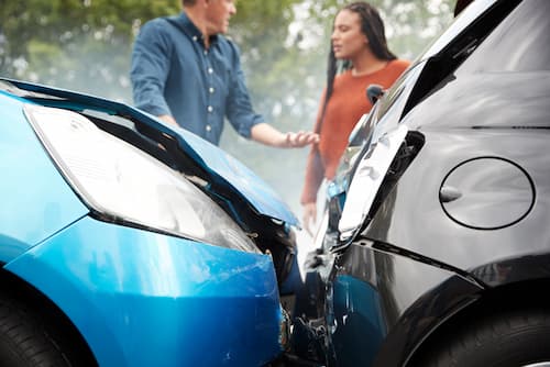 Car crash and two individuals in the back discussing the accident