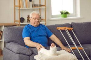 Elderly person sitting watching his broken foot