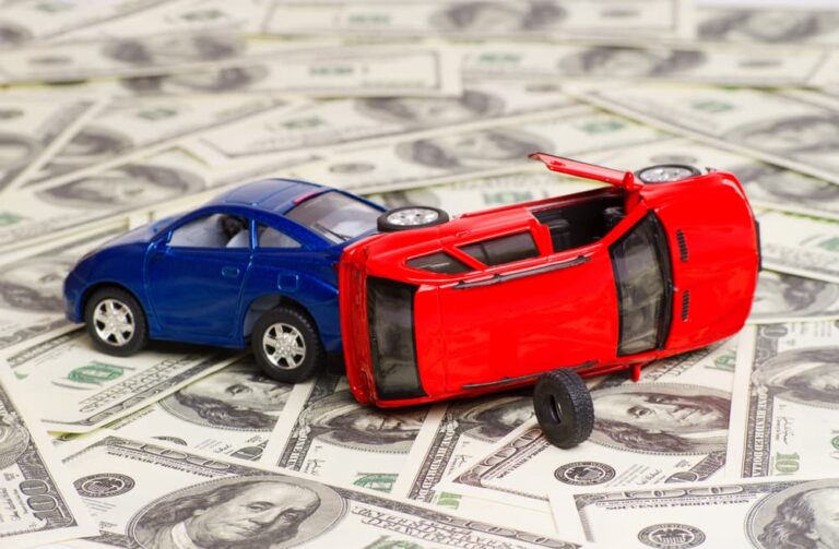 two toy cars on a pile of money; learn the benefits of Medical Insurance for Alabama drivers