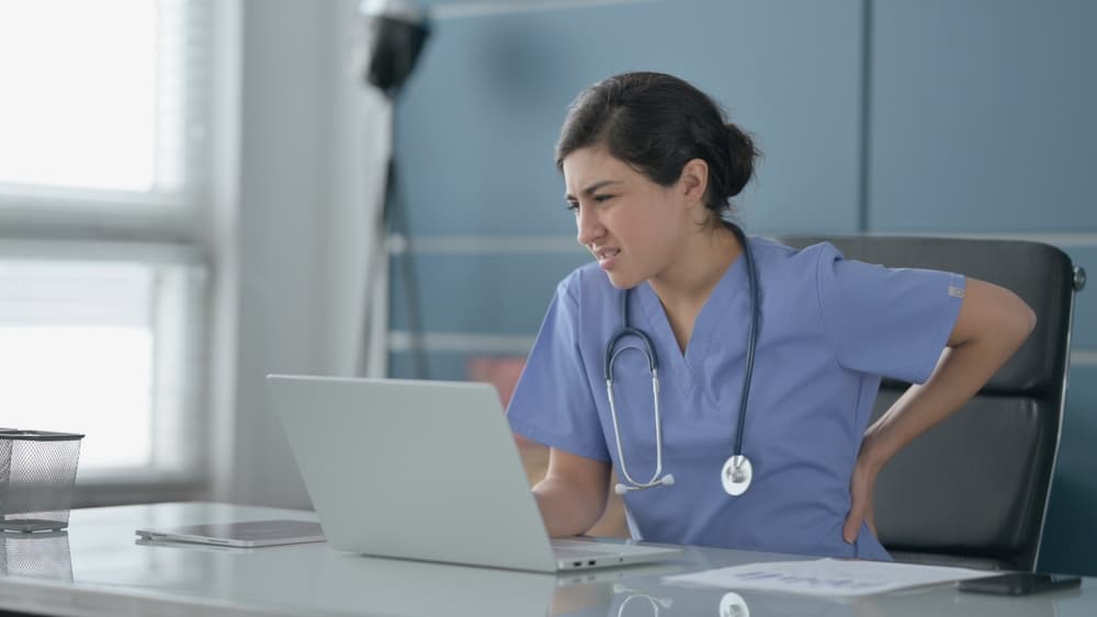 health care professional holding her back in pain after an on the job accident