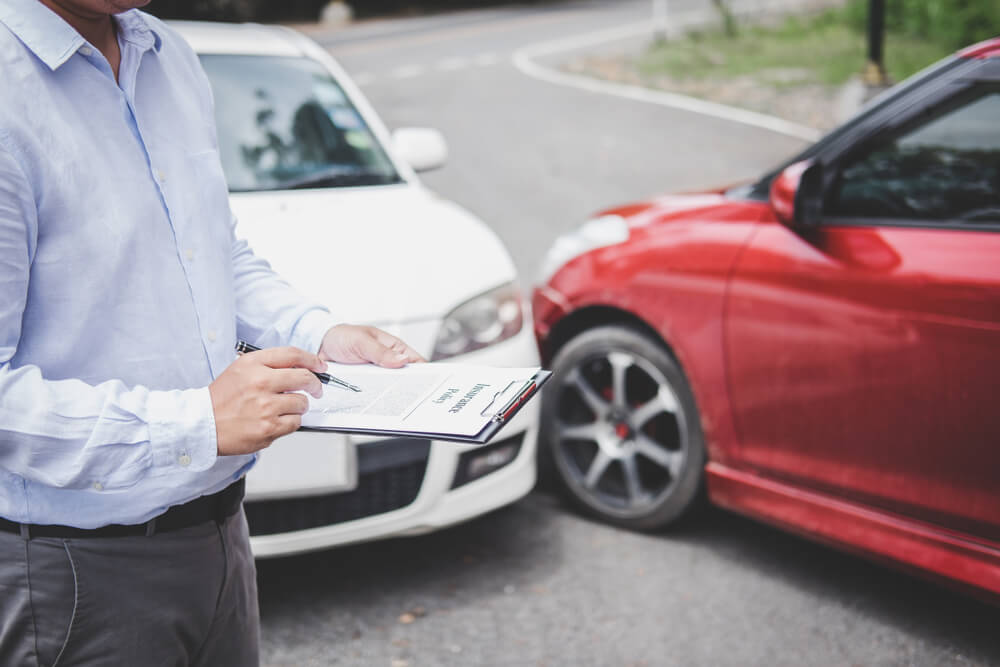 Traffic Accident and insurance concept, Insurance agent working on report form with car accident claim process.