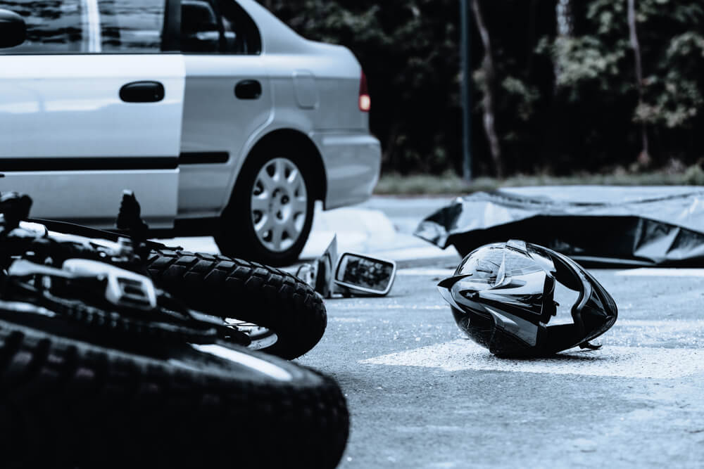 Motorcycle helmet on the street after terrible car crash.