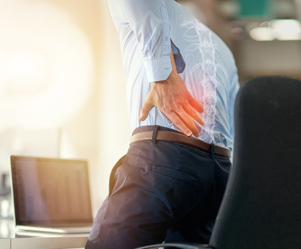 Employee male suffering spinal injury or slip disk with ache, inflammation or painful joint