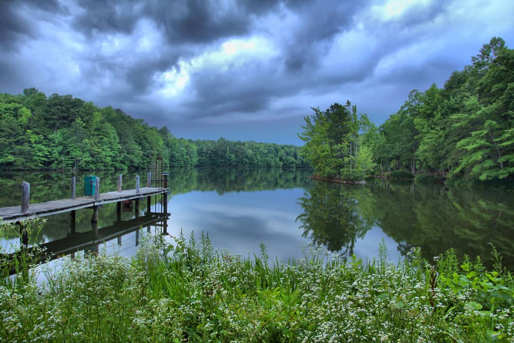 A dock on a lake, under a cloudy sky.