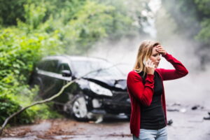 woman in red jacket holding her head after a car accident