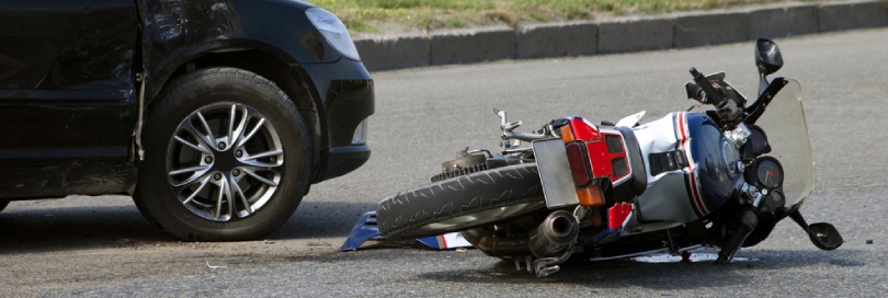 Motorcycle on the ground after colliding with a vehicle