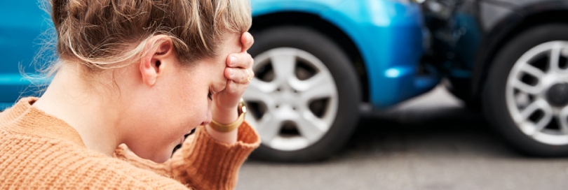 Woman in pain holds her head after a car accident