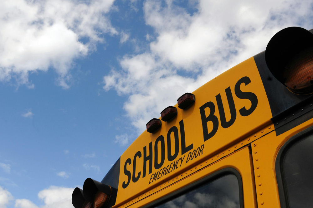 the rear of a yellow school bus that says school bus emergency door