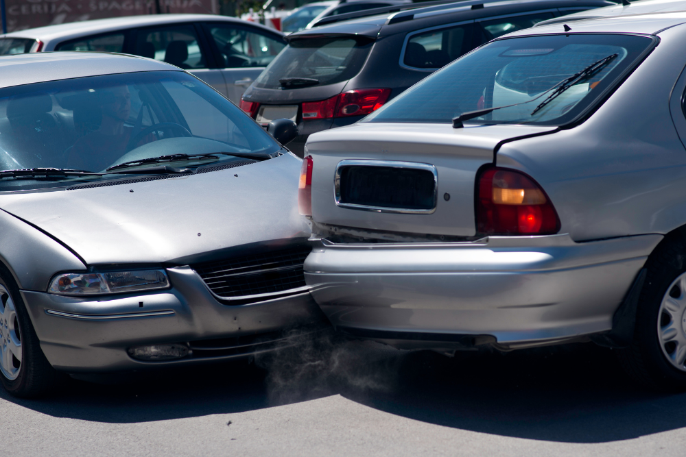 two silver cars in collision in parking lot